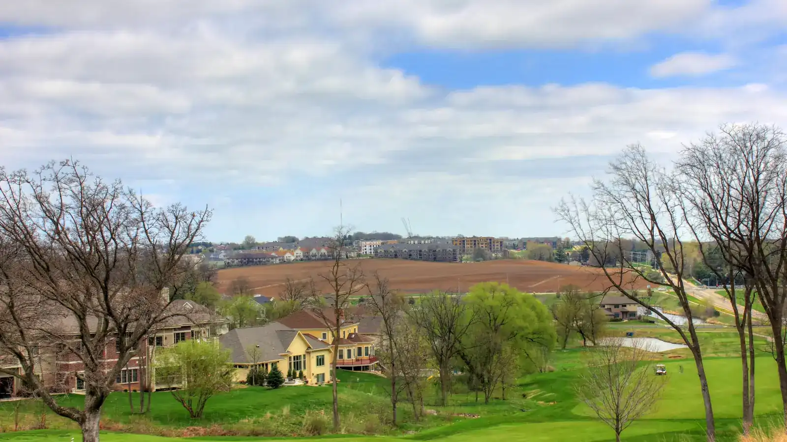A green golf-course landscape under a wide sky
